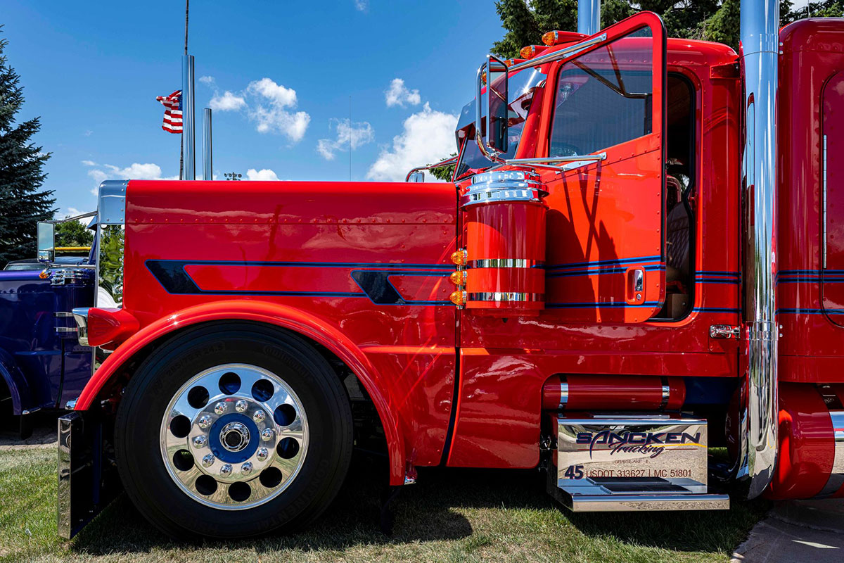 Red Peterbilt with blue graphics, drivers door open